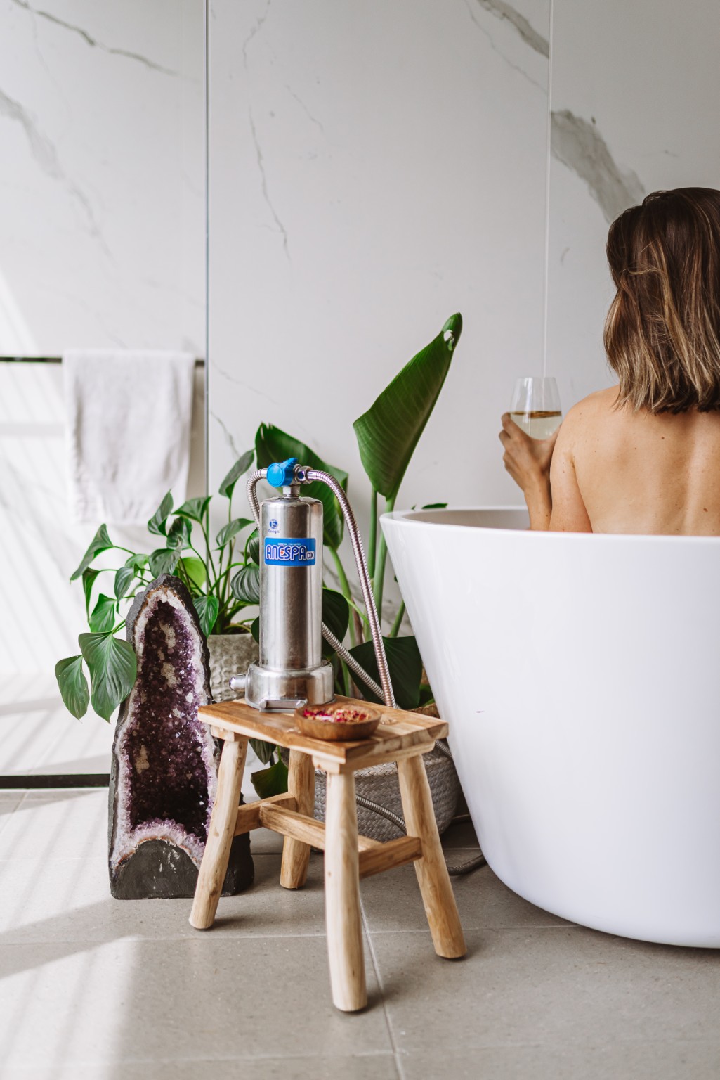 Anespa DX home spa system beside a freestanding bath